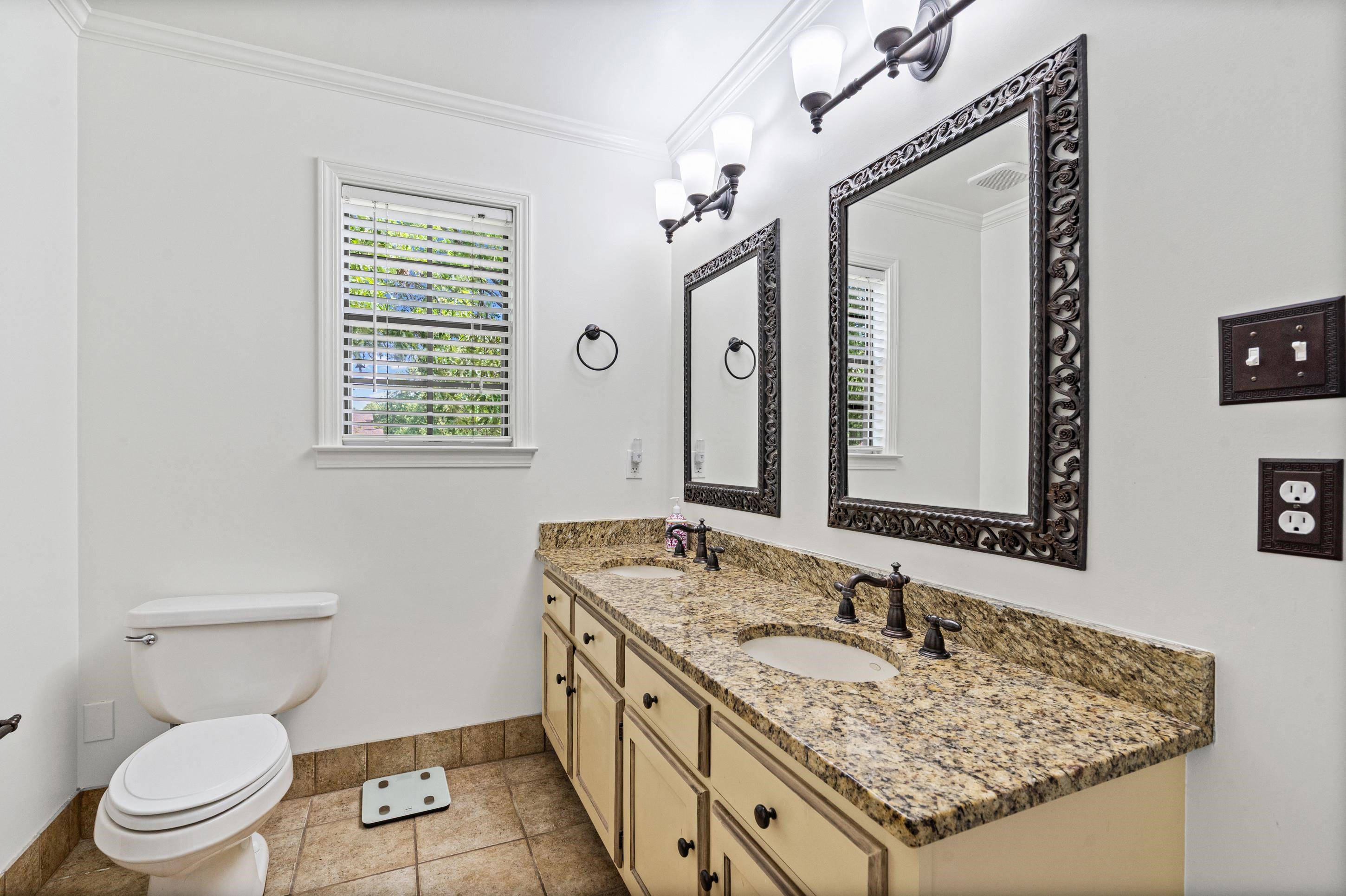 897 Wood Cove Collierville, TN 38017 - Photo 15 of 30 a bathroom with a granite countertop sink a toilet and a mirror