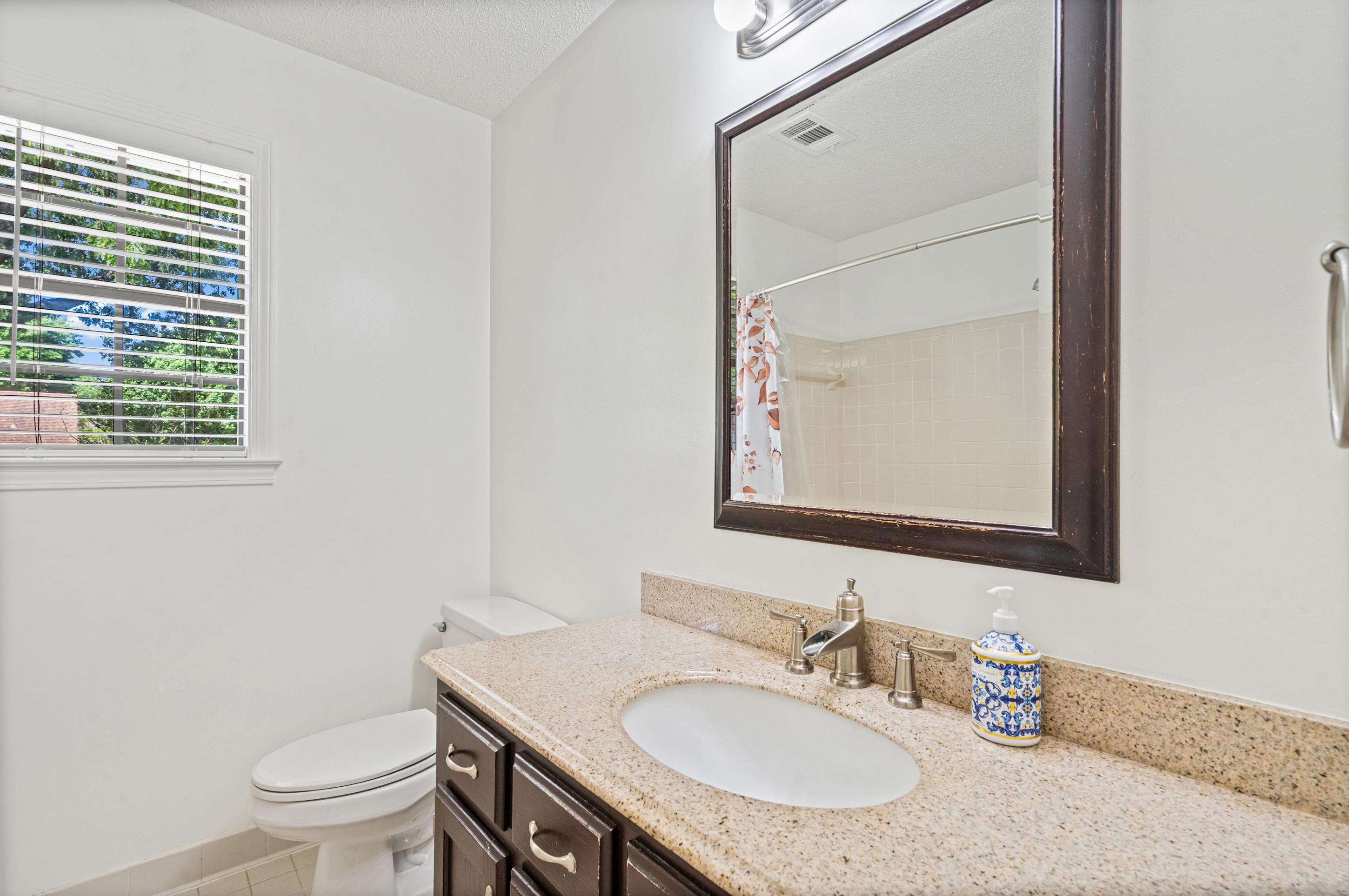 897 Wood Cove Collierville, TN 38017 - Photo 16 of 30 a bathroom with a granite countertop sink a toilet and a mirror