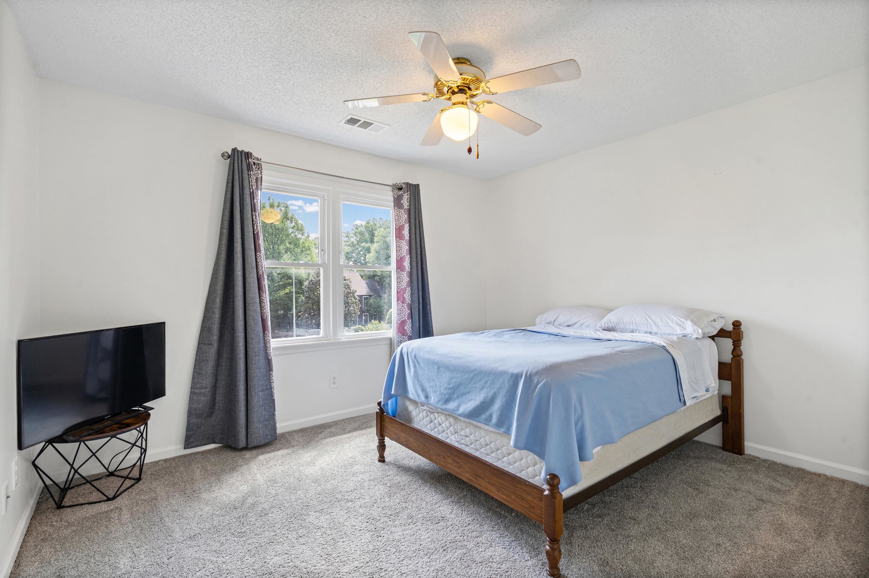 897 Wood Cove Collierville, TN 38017 - Photo 17 of 30 a spacious bedroom with a bed and a flat screen tv