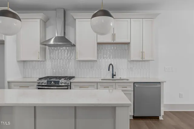 a kitchen with stainless steel appliances a sink a stove and cabinets