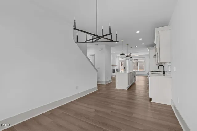 a view of a living room a ceiling fan and wooden floor