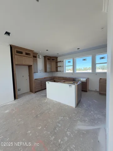 a large kitchen with stainless steel appliances a large counter top a stove and a refrigerator