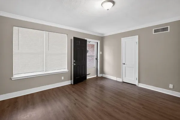 an empty room with wooden floor and closet