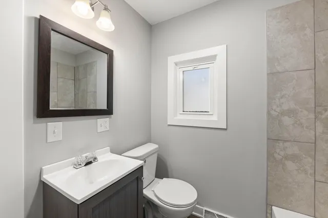 a bathroom with a toilet sink and mirror