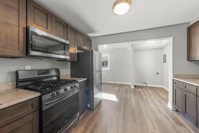 a kitchen with granite countertop a stove and a microwave