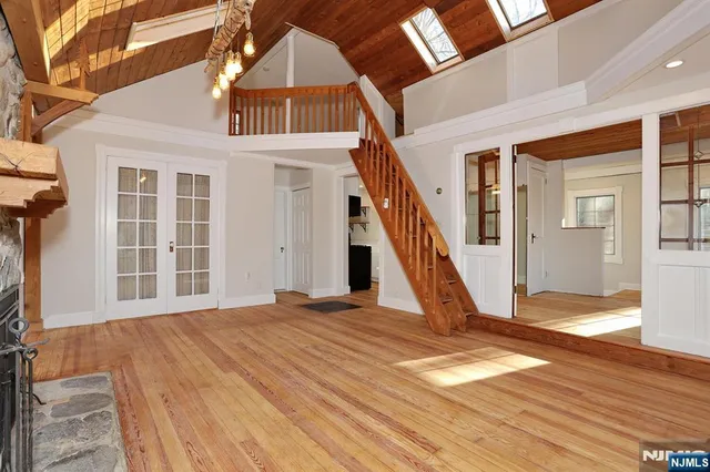 a view of an empty room with wooden floor and a fireplace