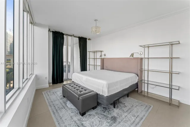 a bedroom with a bed lamp and a large window