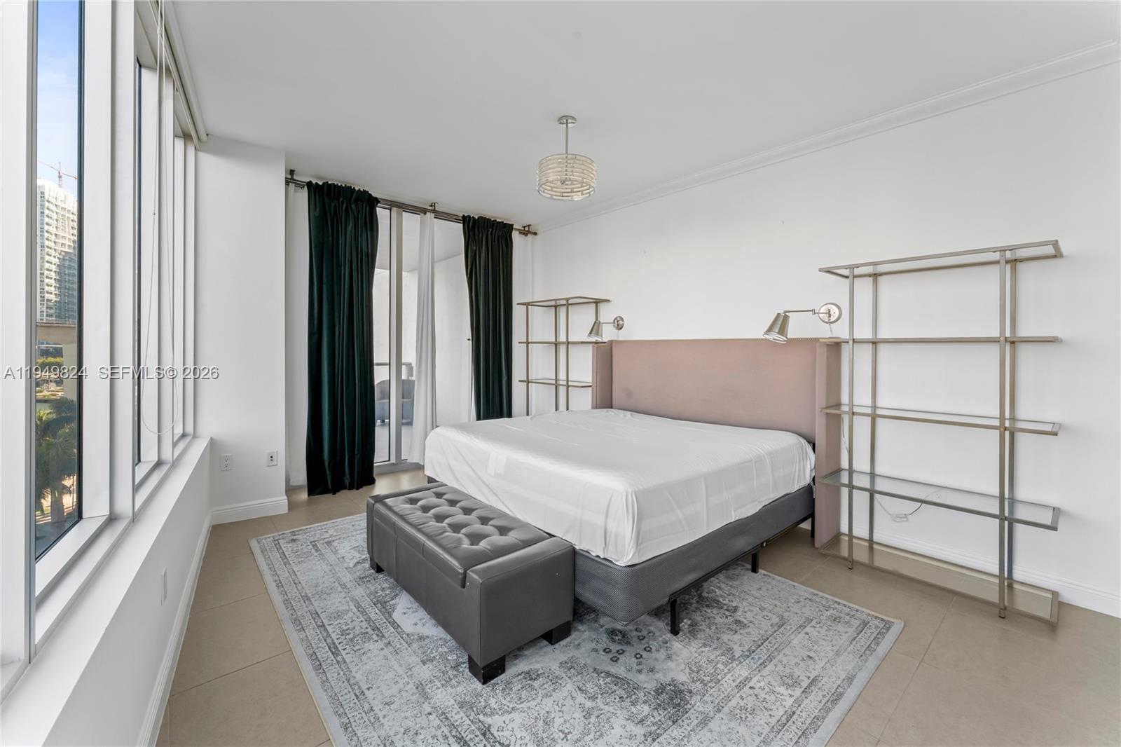 185 Southwest 7th Street, Unit 603 Miami, FL 33130 - Photo 13 of 32 a bedroom with a bed lamp and a large window