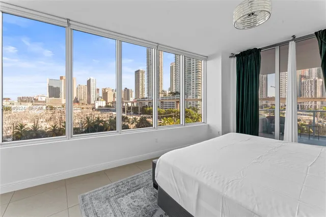 a bedroom with a large window and a balcony