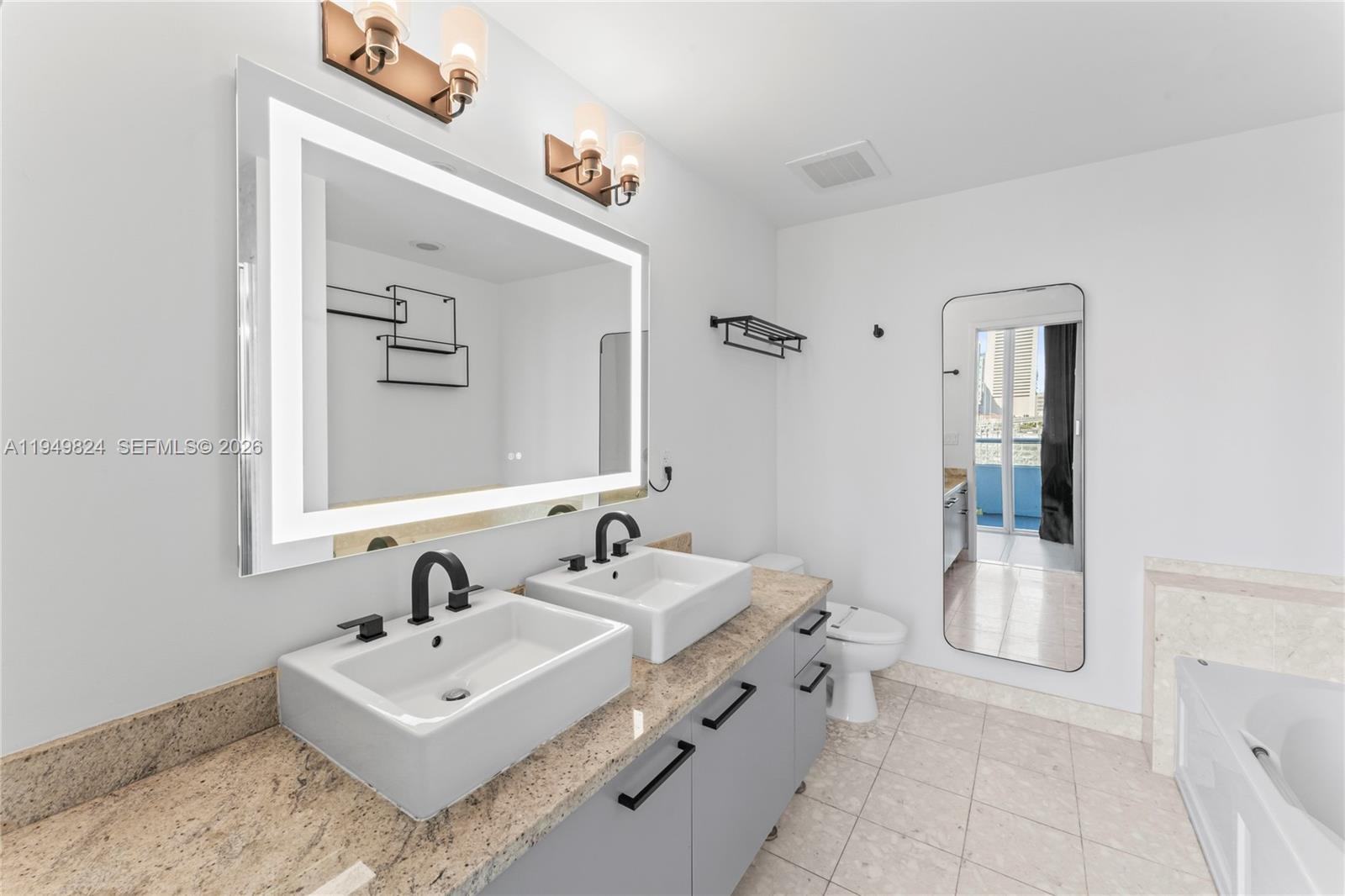 185 Southwest 7th Street, Unit 603 Miami, FL 33130 - Photo 19 of 32 a bathroom with a sink double vanity and mirror