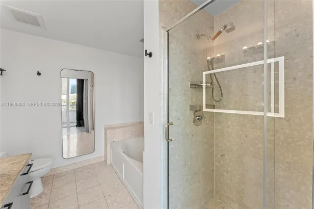 a bathroom with a granite countertop sink toilet and shower