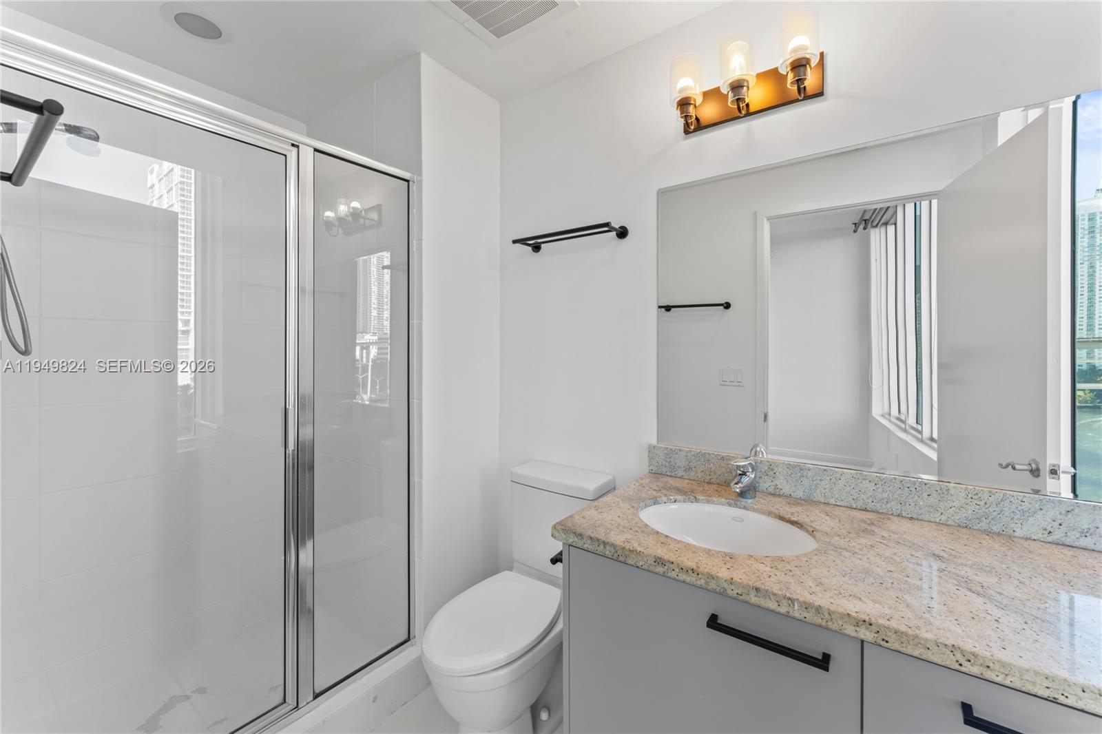 185 Southwest 7th Street, Unit 603 Miami, FL 33130 - Photo 22 of 32 a bathroom with a granite countertop sink toilet and shower
