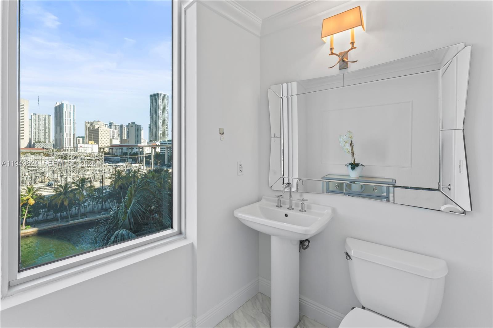 185 Southwest 7th Street, Unit 603 Miami, FL 33130 - Photo 24 of 32 a bathroom with a sink mirror and toilet