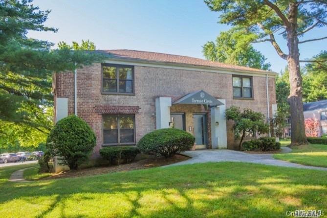 a front view of a house with a yard and trees
