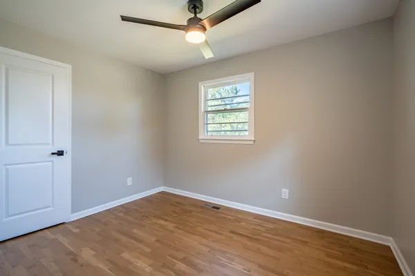 an empty room with a window and a ceiling fan