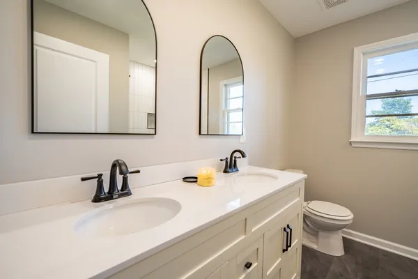 a bathroom with a toilet sink and mirror