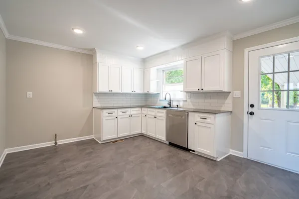 a kitchen with granite countertop white cabinets and white appliances