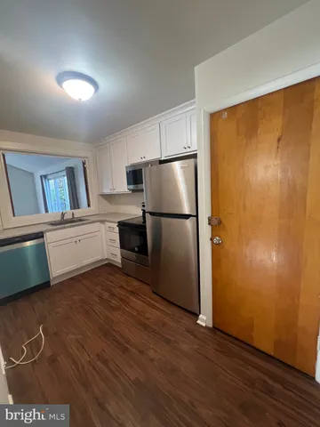 a kitchen with cabinets and wooden floor