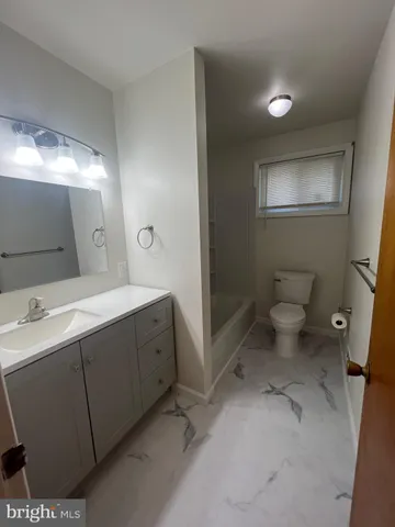 a spacious bathroom with a double vanity sink toilet and a mirror