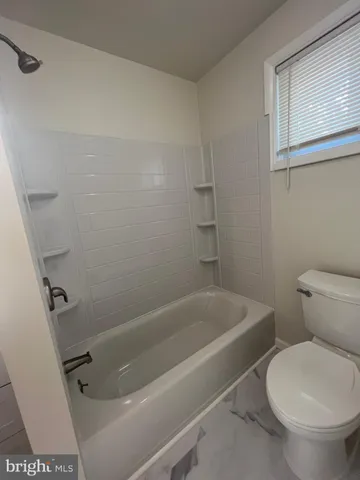 a white bath tub sitting next to a toilet