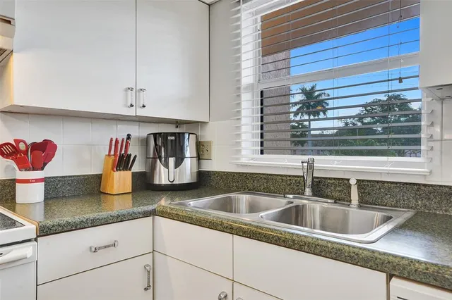 a living room with furniture a large window and a dining table