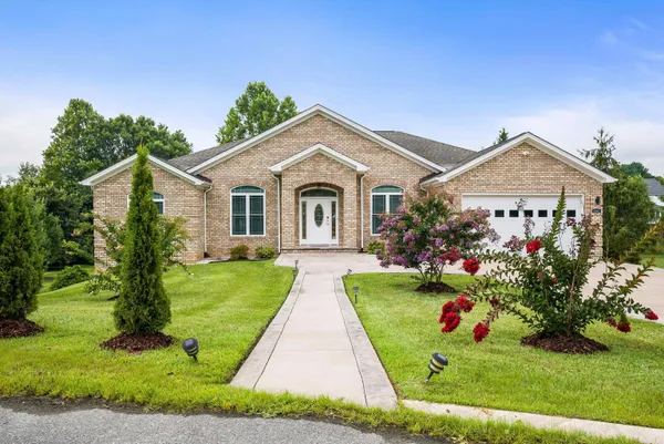 a front view of a house with a garden and plants