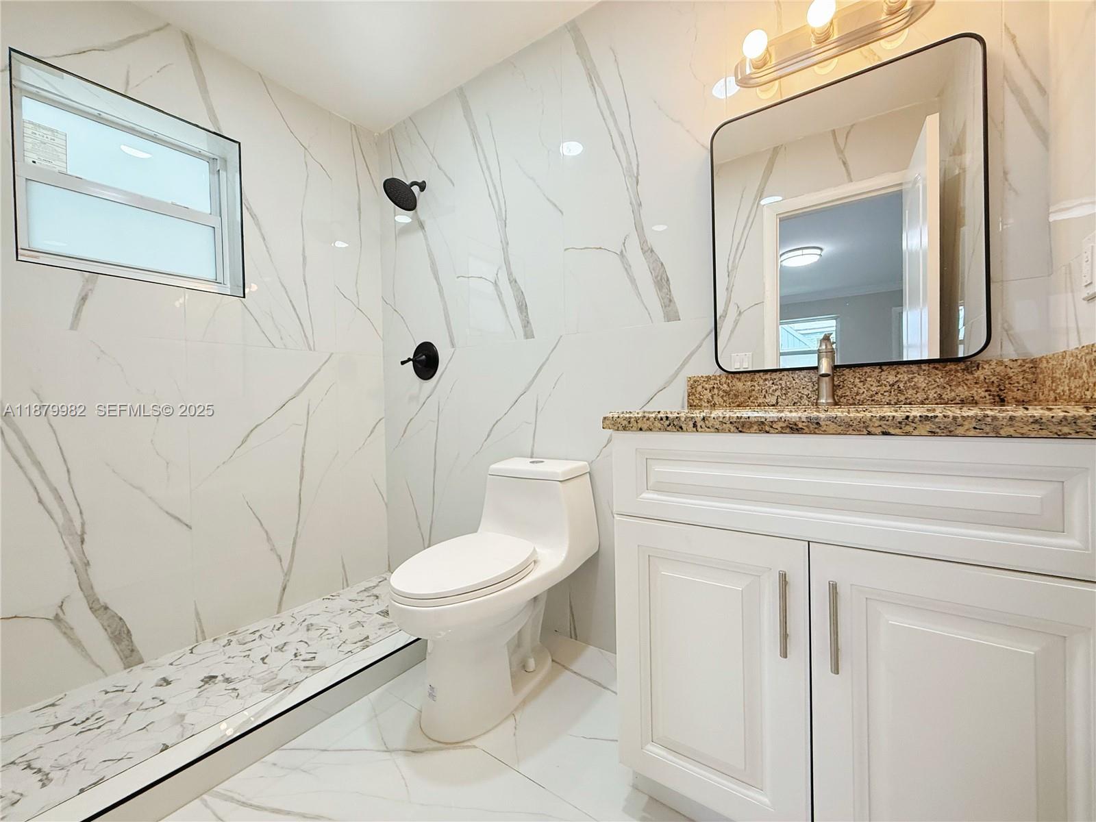 1666-1668 Southwest 9th Street Miami, FL 33135 - Photo 11 of 26 a bathroom with a granite countertop toilet sink and mirror