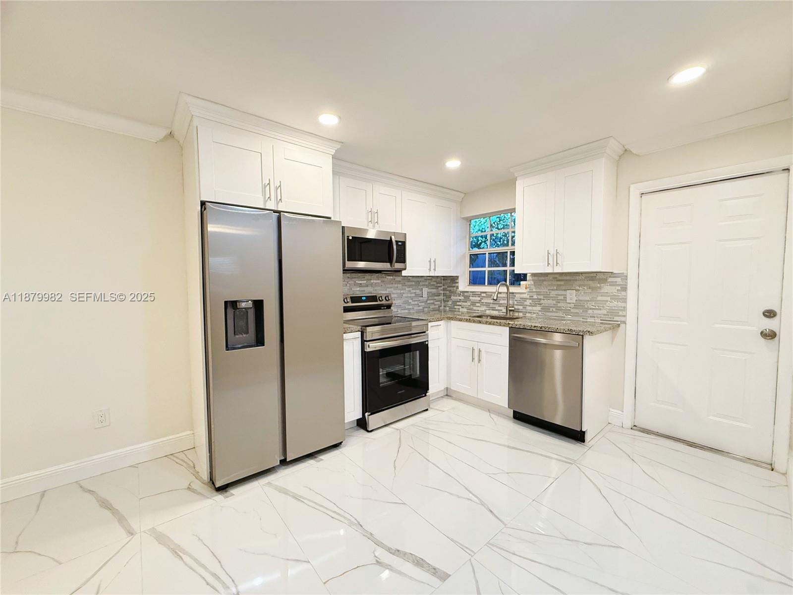 1666-1668 Southwest 9th Street Miami, FL 33135 - Photo 15 of 26 a kitchen with stainless steel appliances a refrigerator sink and cabinets