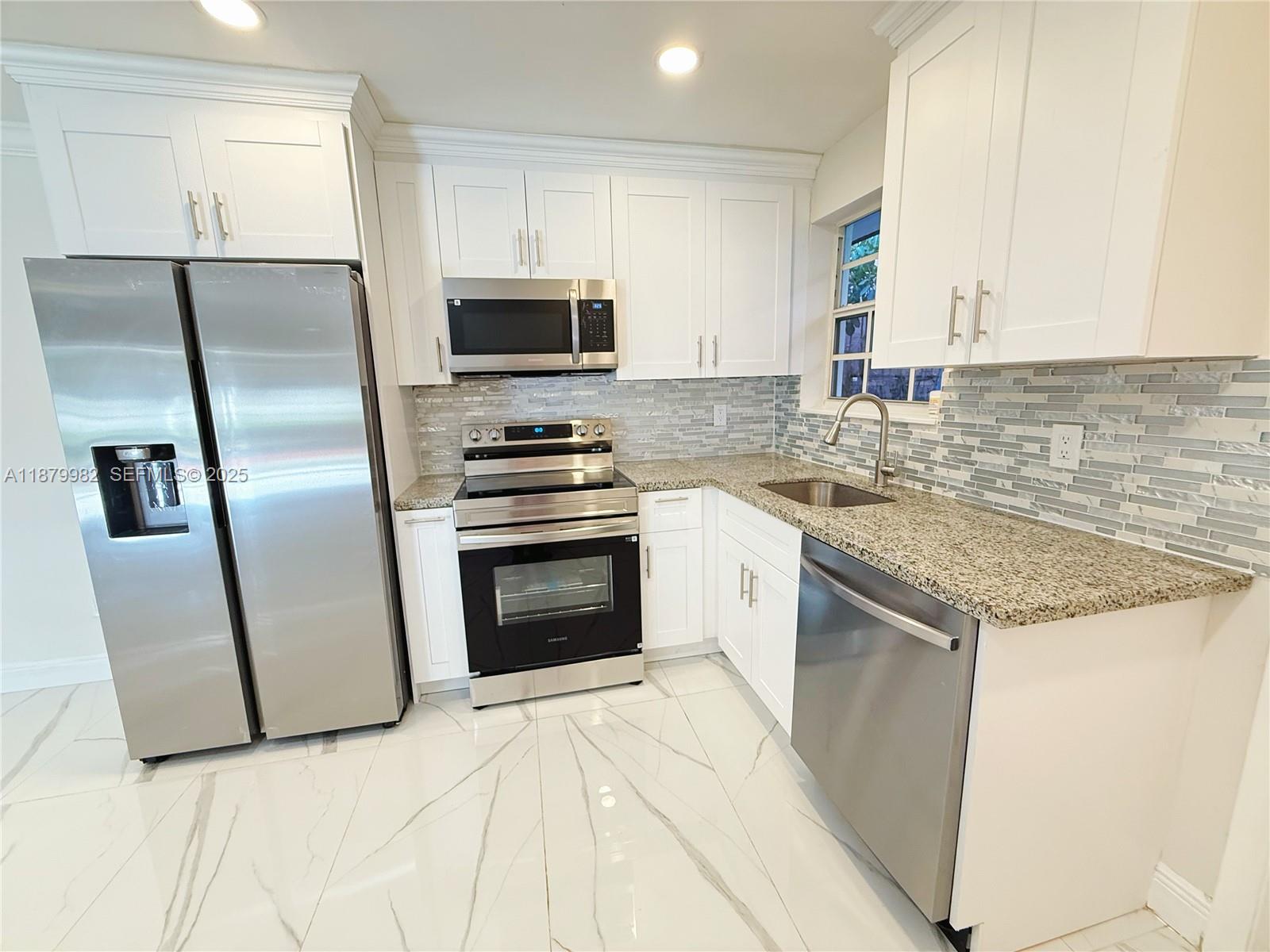 1666-1668 Southwest 9th Street Miami, FL 33135 - Photo 16 of 26 a kitchen with stainless steel appliances granite countertop a stove a refrigerator and a sink
