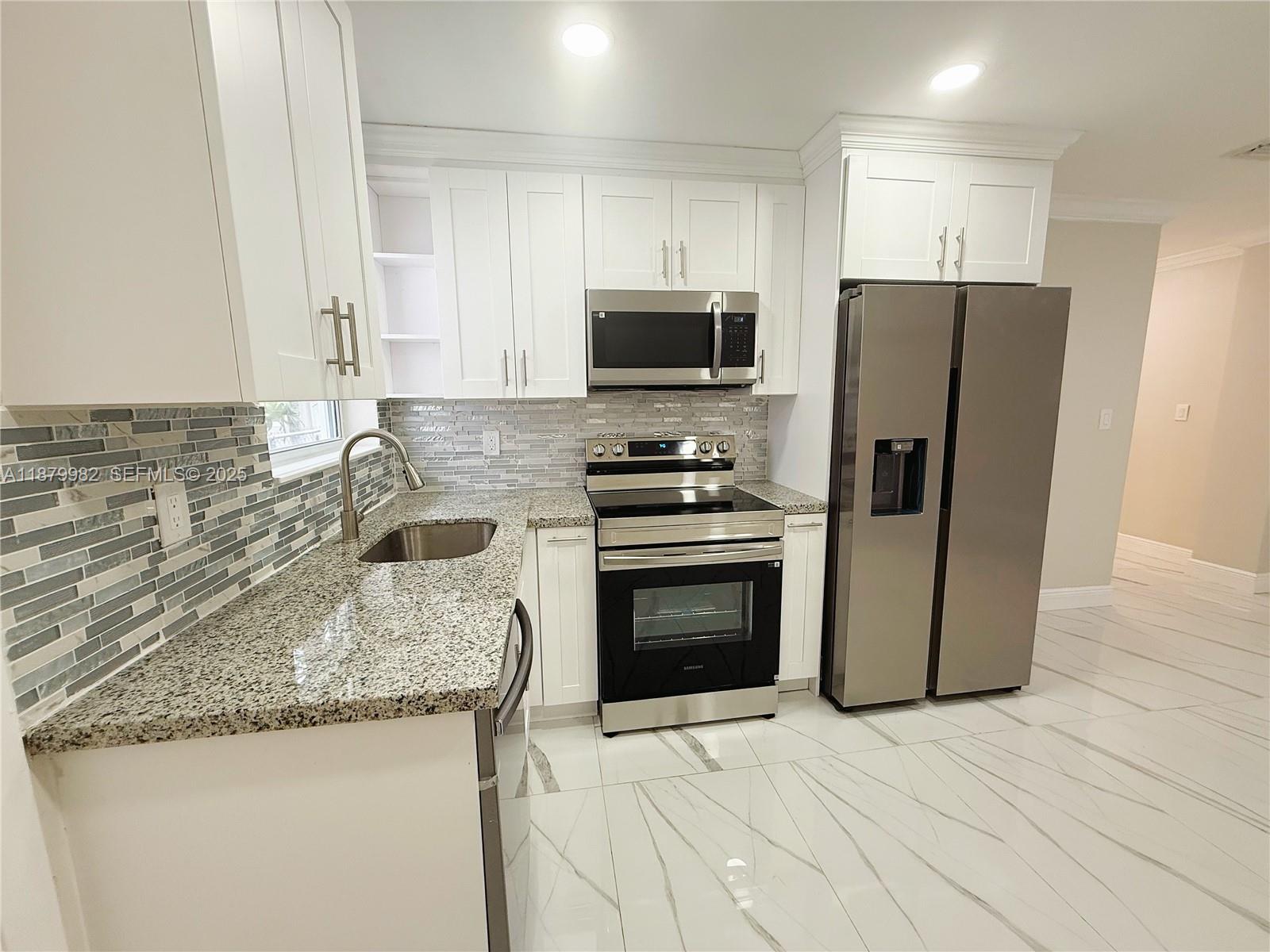 1666-1668 Southwest 9th Street Miami, FL 33135 - Photo 5 of 26 a kitchen with granite countertop a refrigerator stove and microwave