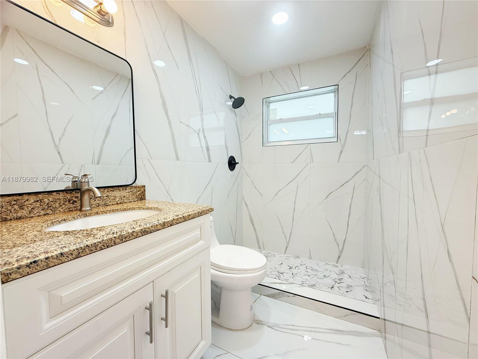 1666-1668 Southwest 9th Street Miami, FL 33135 - Photo 9 of 26 a bathroom with a granite countertop sink a toilet and a mirror