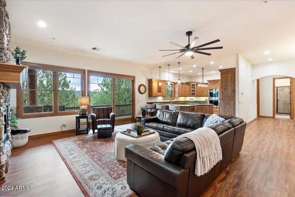 a spacious bedroom with a bed couch and a large window with wooden floor