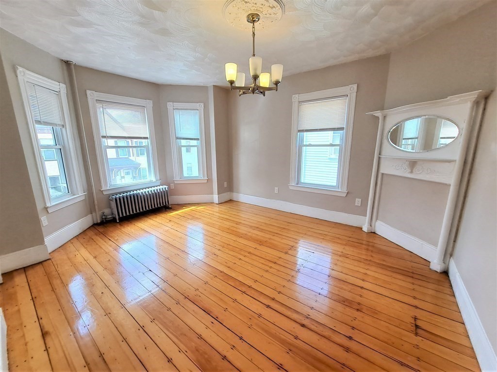 35 Catawba Street, Unit 2 Boston, MA 02119 - Photo 1 of 14 a view of an empty room with wooden floor and a window
