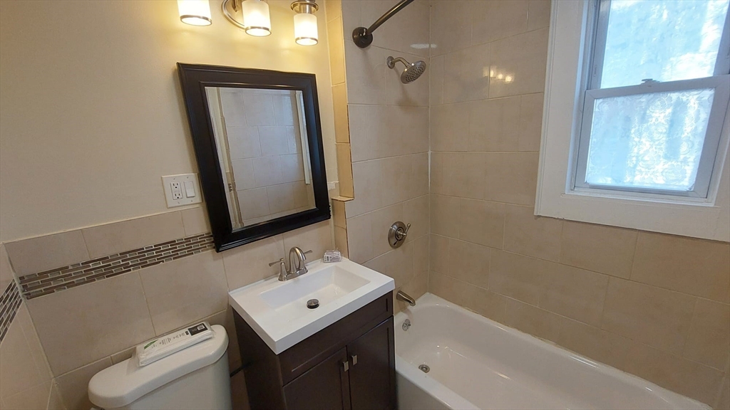 35 Catawba Street, Unit 2 Boston, MA 02119 - Photo 13 of 14 a bathroom with a toilet sink and mirror