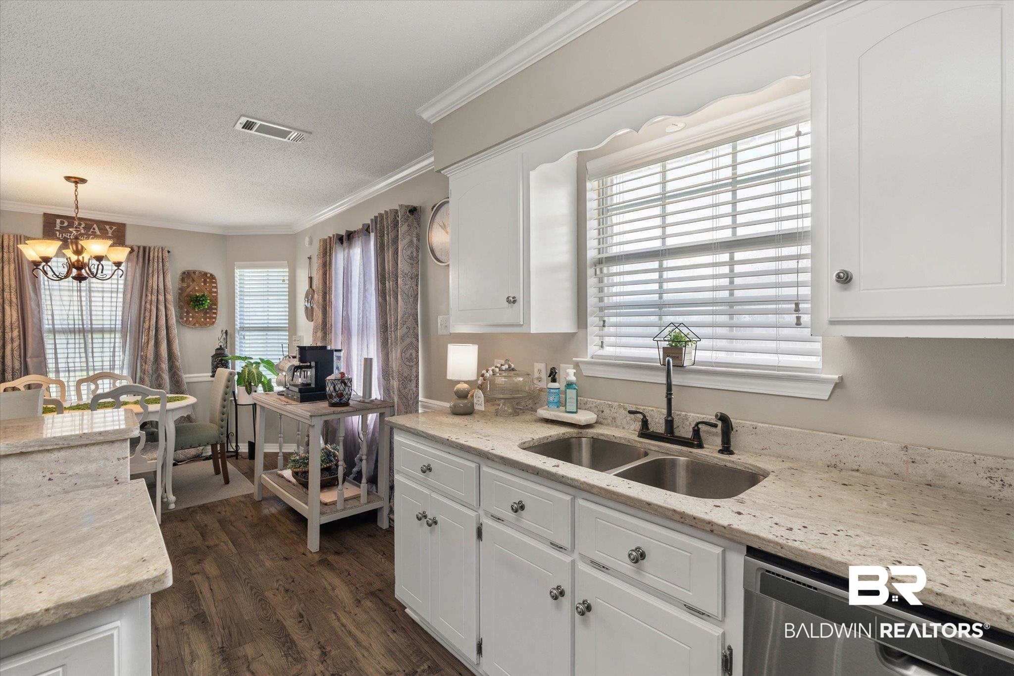 8600 Sable Court Semmes, AL 36575 - Photo 7 of 20 Kitchen featuring dishwasher, a chandelier, crown molding, white cabinetry, and dark wood finished floors