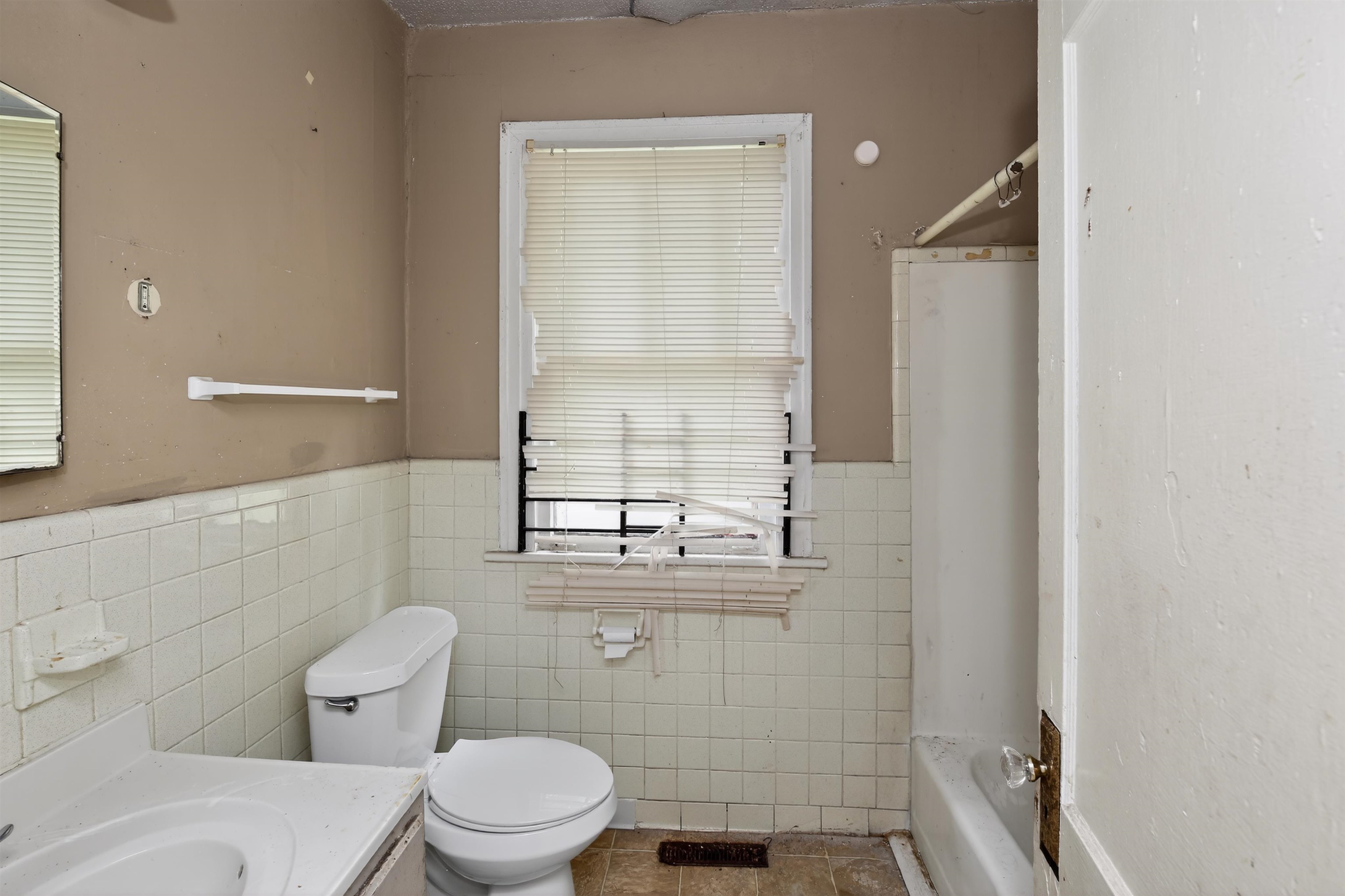 810 Hale Road Memphis, TN 38116 - Photo 22 of 30 Bathroom featuring a window with blinds, white wall tiling, a toilet, a sink vanity, and a bathtub