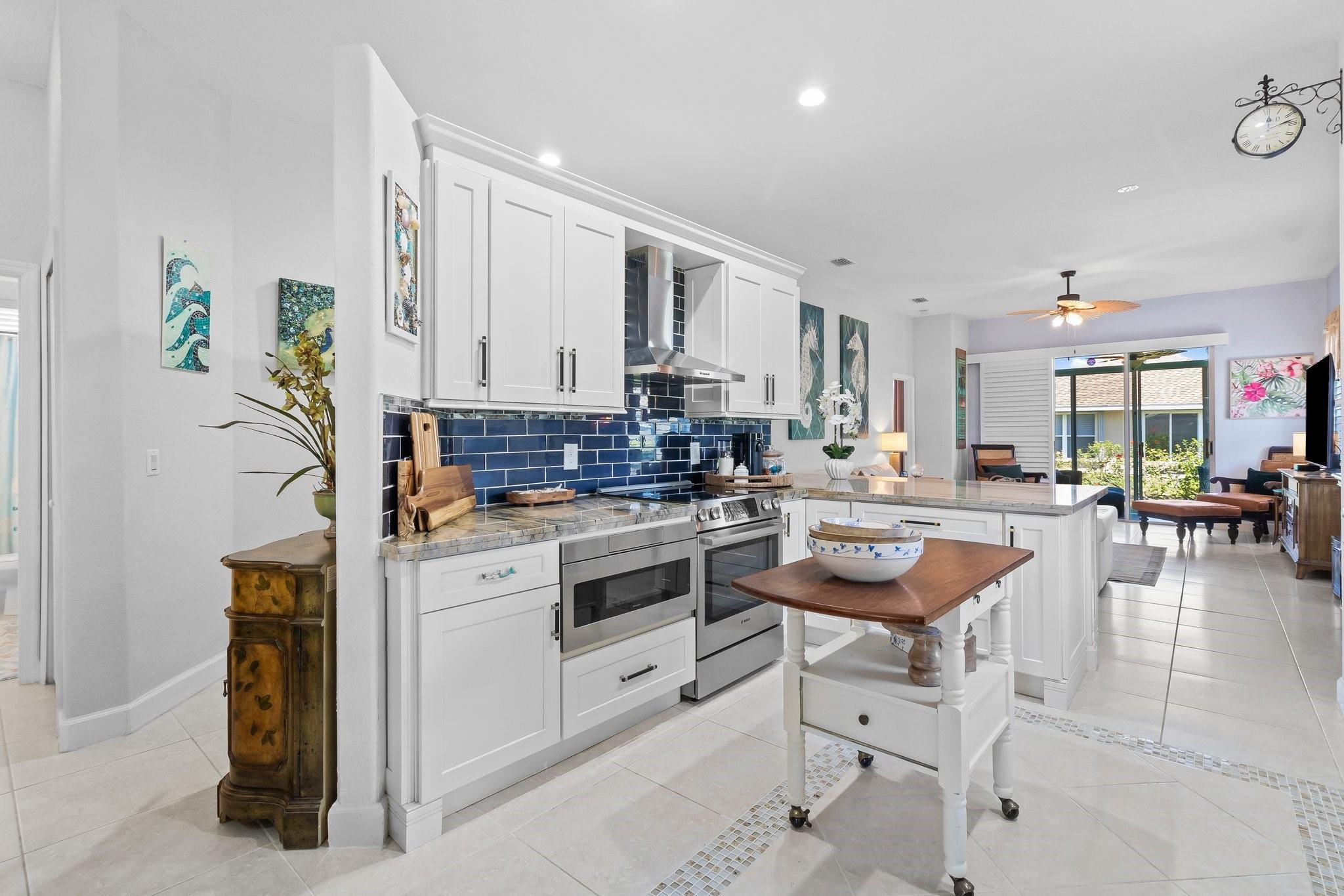 3017 Ocelot Way Fort Pierce, FL 34949 - Photo 13 of 20 a kitchen with stainless steel appliances kitchen island granite countertop a stove a sink and a refrigerator