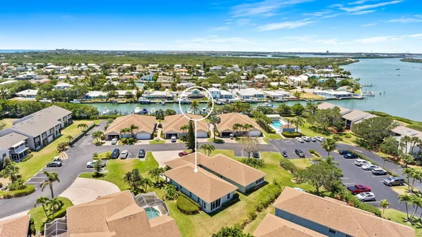 an aerial view of ocean and residential houses with outdoor space