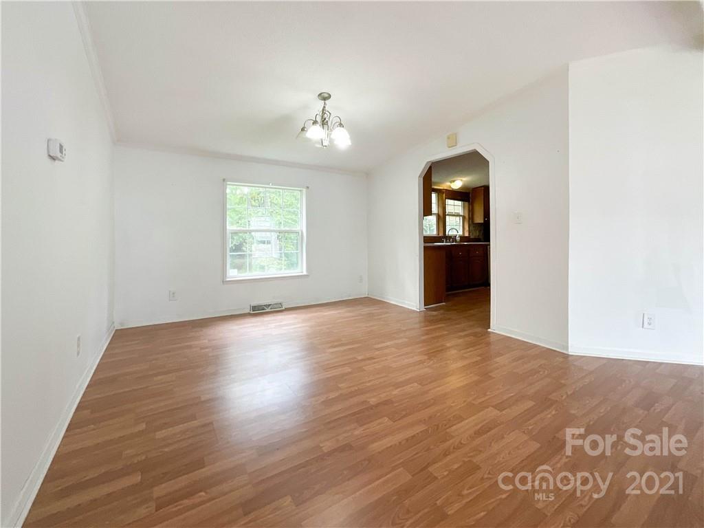 3512 Edwards Road Wingate, NC 28174 - Photo 13 of 42 an empty room with wooden floor chandelier and windows