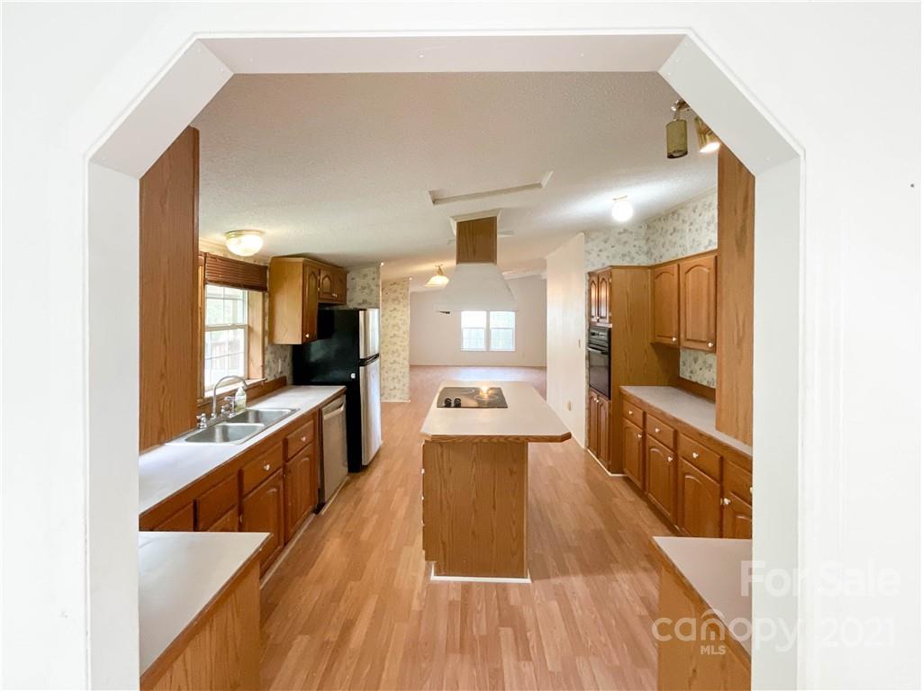 3512 Edwards Road Wingate, NC 28174 - Photo 15 of 42 a large white kitchen with kitchen island a counter top space a sink and stainless steel appliances