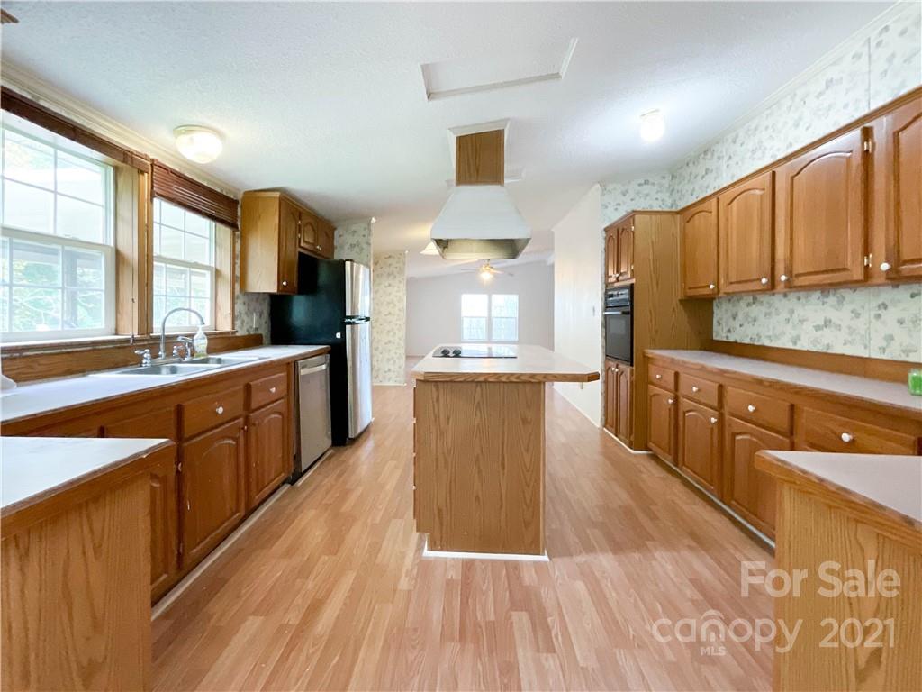 3512 Edwards Road Wingate, NC 28174 - Photo 16 of 42 a large kitchen with stainless steel appliances kitchen island granite countertop a large counter top a sink a stove a refrigerator and cabinets