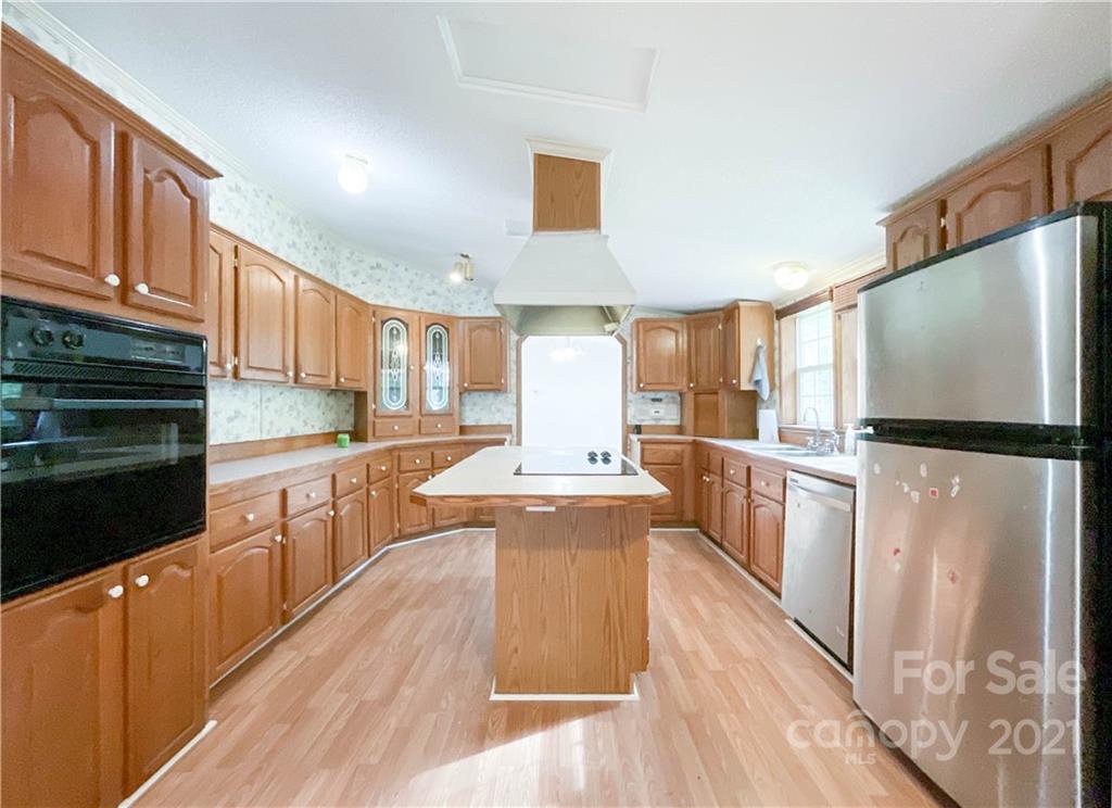 3512 Edwards Road Wingate, NC 28174 - Photo 19 of 42 a kitchen with stainless steel appliances a stove top oven a refrigerator a sink and dishwasher with wooden floor