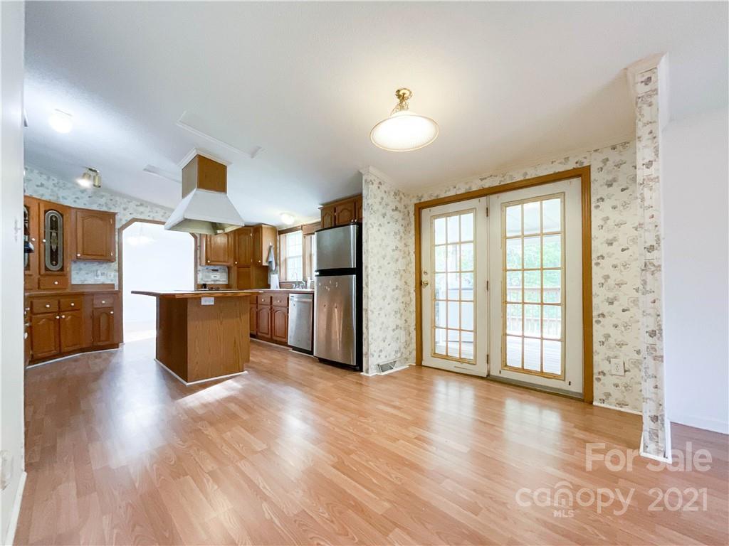3512 Edwards Road Wingate, NC 28174 - Photo 20 of 42 a kitchen with stainless steel appliances kitchen island wooden floors wooden cabinets and entryway