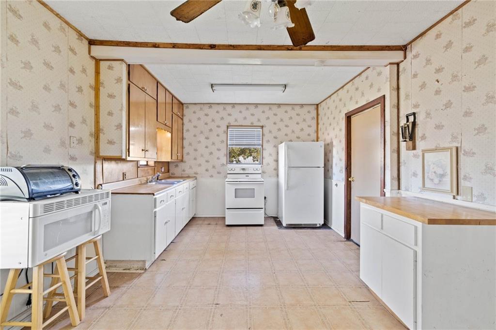 211 7th Street Jarrell, TX 76537 - Photo 10 of 26 a large white kitchen with stainless steel appliances granite countertop a stove a sink and a refrigerator