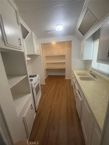 a kitchen with granite countertop white cabinets and white appliances