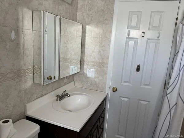 a bathroom with a toilet sink and mirror