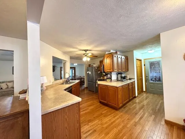 a large kitchen with kitchen island a large counter top and stainless steel appliances