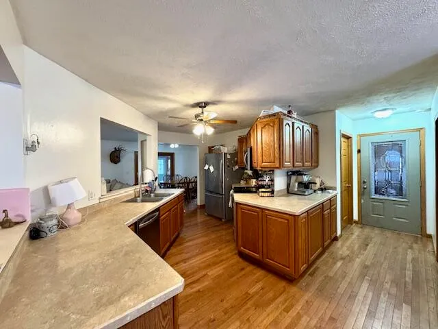 a living room with kitchen island granite countertop wooden floor and stainless steel appliances