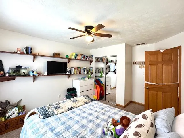 a bedroom with a bed and a view of kitchen