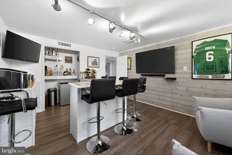 a view of a livingroom with furniture a flat screen tv and wooden floor